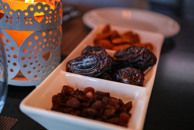 Foto van dadels en rozijnen bij een kaarsje tijdens ramadan.