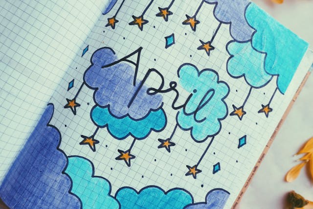 In een boek is een tekening gemaakt van paarse en blauwe gekleurde wolkjes waar sterretjes onder hangen met in het midden 'April' geschreven.