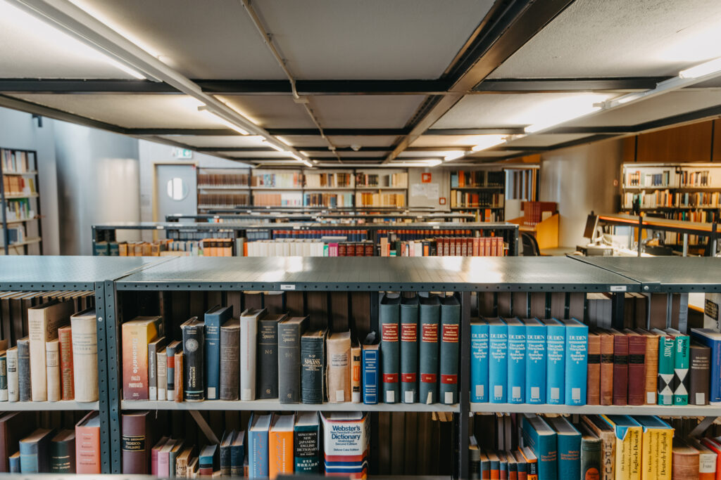 Foto van een bibliotheek met woordenboeken uit meerdere talen.