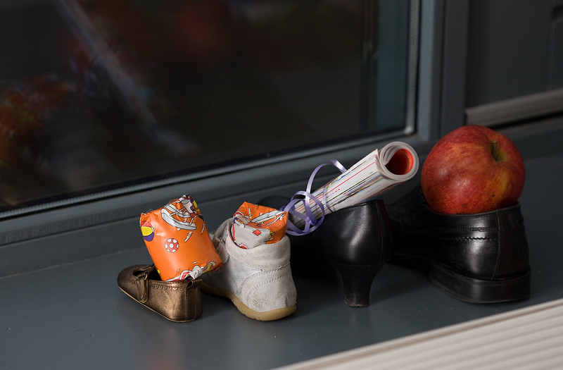 Vier schoenen gezet voor Sinterklaas. Elke schoen is gevuld met een cadeautje.